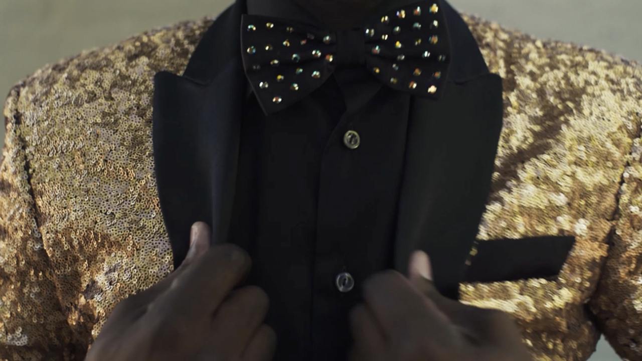 Zoomed image to the chest of a person wearing a gold sequence jacket