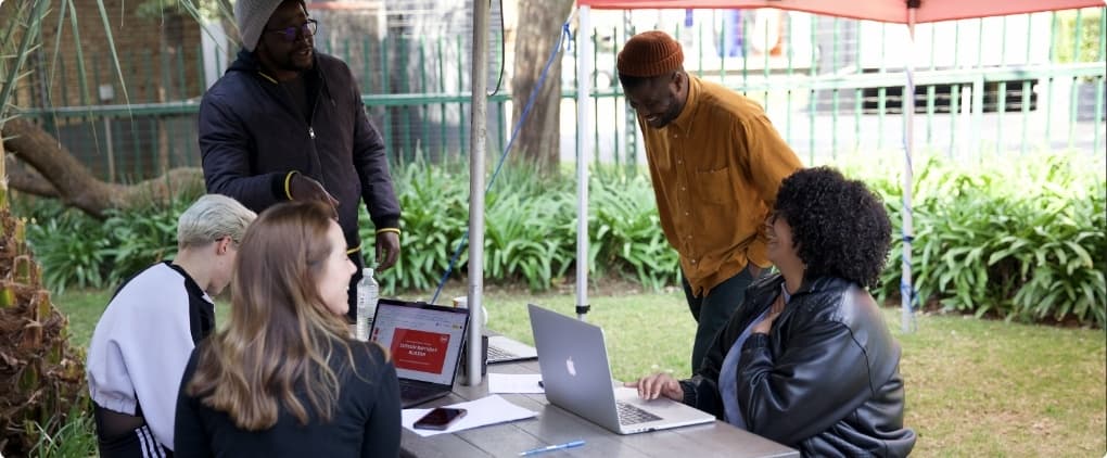 People working outside in the garden on laptops