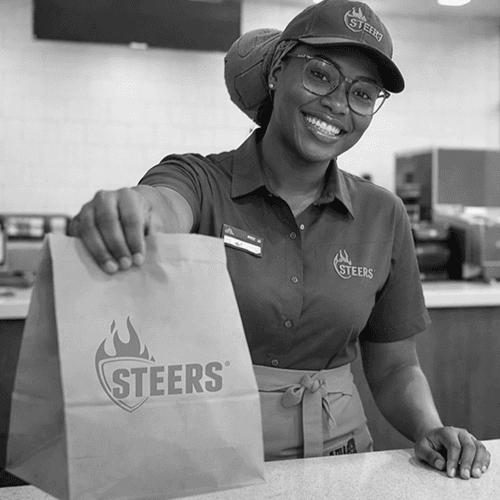 A Steers meal with burger, chips, and drink in a store environment