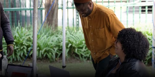 People working outside in the garden on laptops