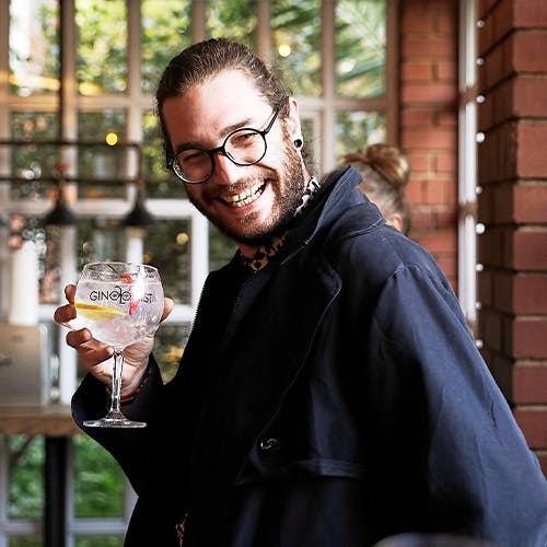 Smiling man drinking gin and tonic