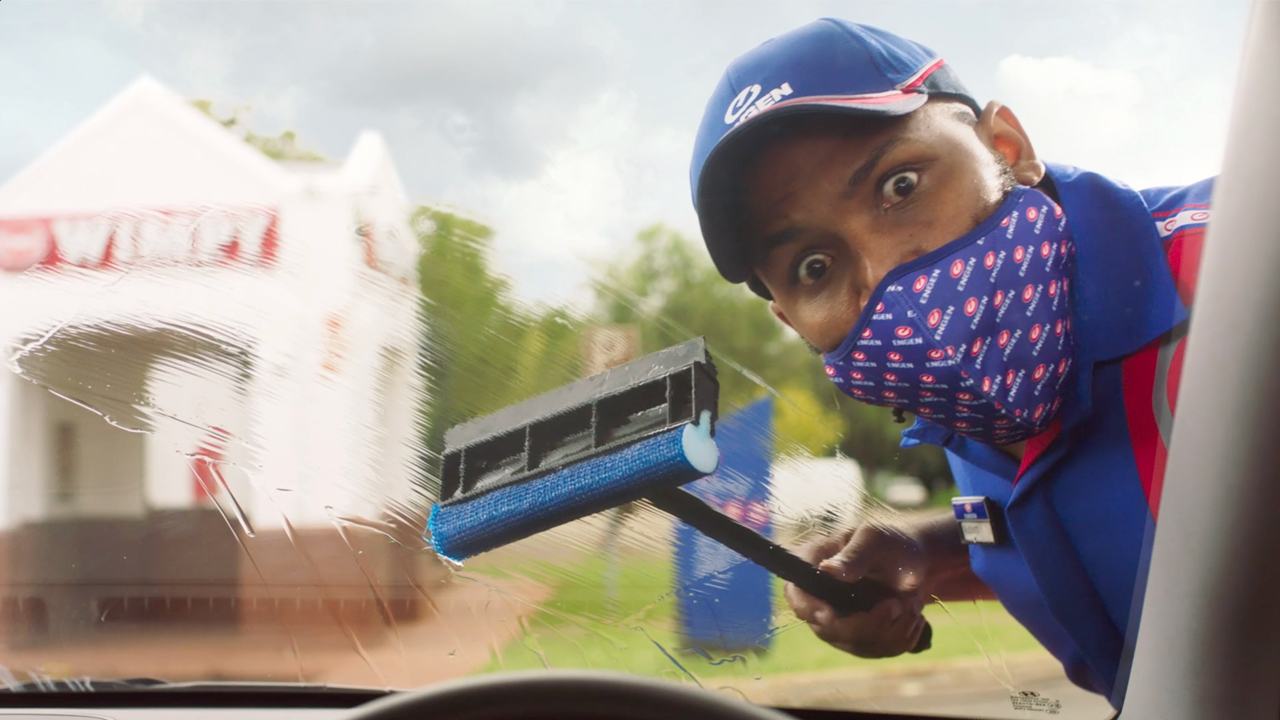 Person at petrol station cleaning windscreen window with suprise look